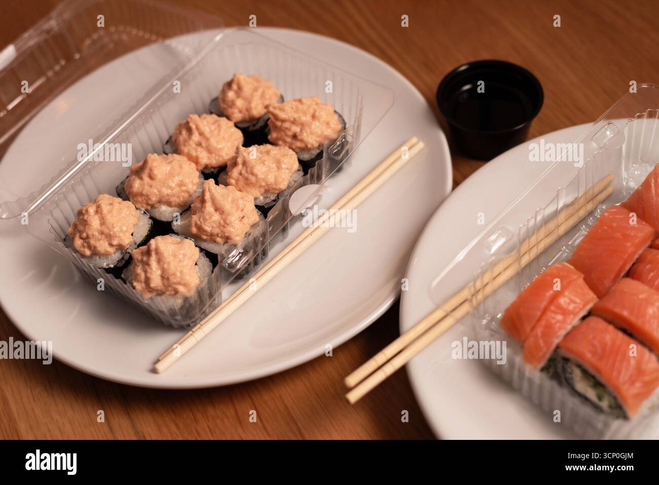 Auf der knusprigen weißen Platte gibt es eine Auswahl an Sushi: Lachsnigiri und Brötchen mit einer cremigen Thunfisch- oder Krabbenmischung. Ideal für Restaurantmenüs Stockfoto