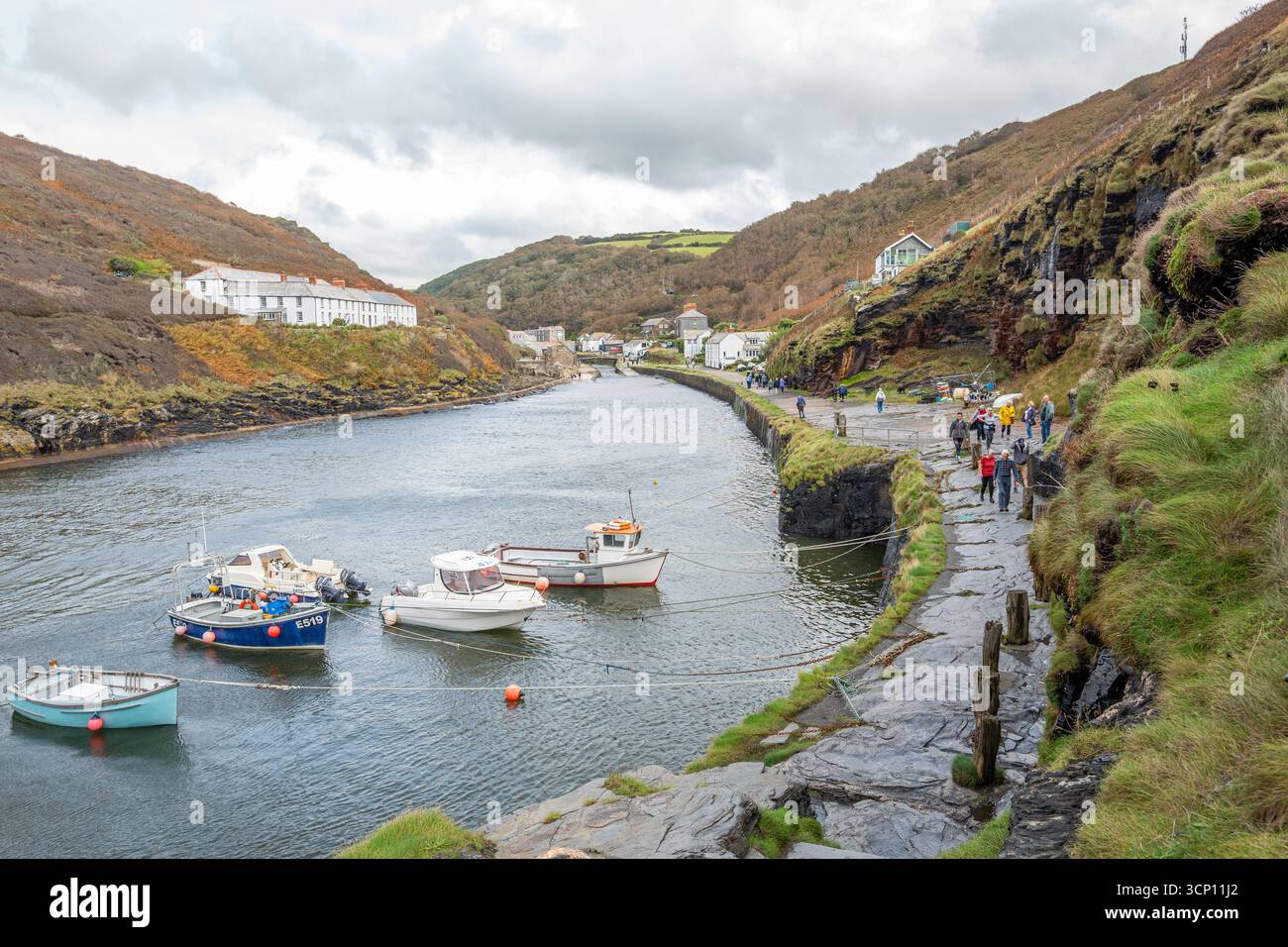 Der natürliche Hafen im kleinen kornischen Fischerdorf Boscastle mit kleinen Fischerbooten und Schiffen, die an der künstlichen Meeresmauer verankert sind. Stockfoto