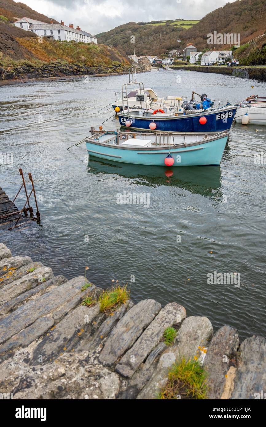 Der natürliche Hafen im kleinen kornischen Fischerdorf Boscastle mit kleinen Fischerbooten und Schiffen, die an der künstlichen Meeresmauer verankert sind. Stockfoto