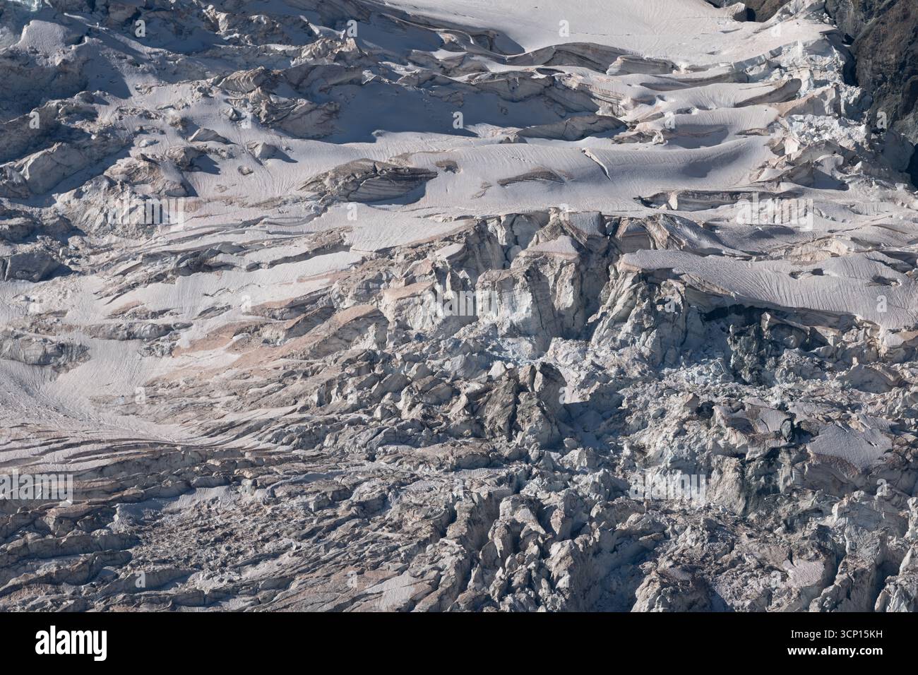 Spektakulärer Gletscher entfaltet sich unter Licht und zeigt seine Spalten und seine Eisschichten in Bergregionen. Grautöne unterstreichen die Schönheit des Gletschers Stockfoto