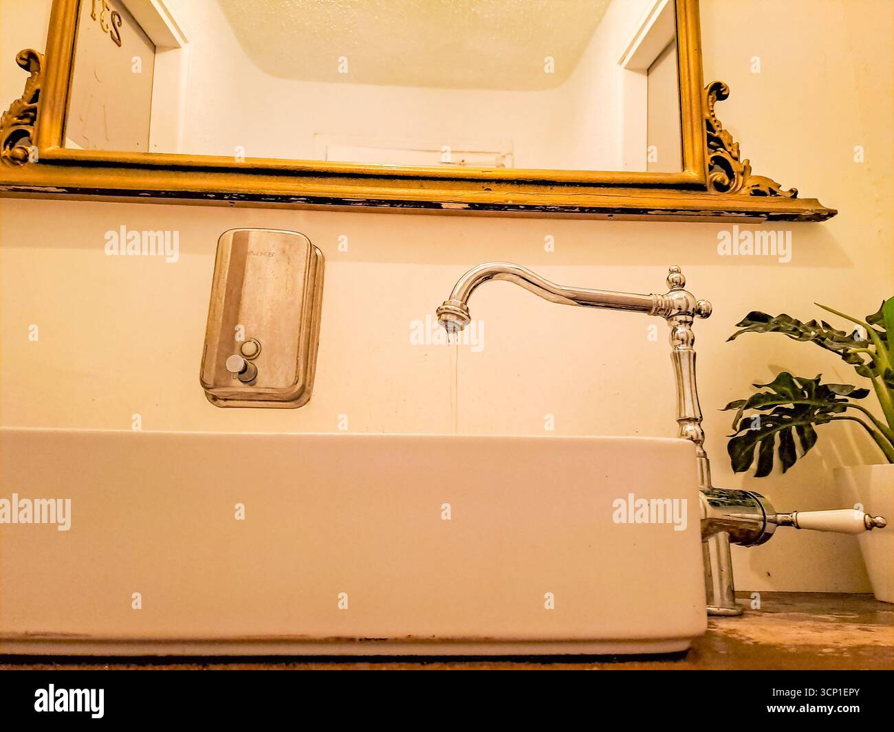 Wasserhahn in Vintage-Silber mit fließendem Wasser mit Waschbecken und Seifenspender. Hochwertige Fotos Stockfoto