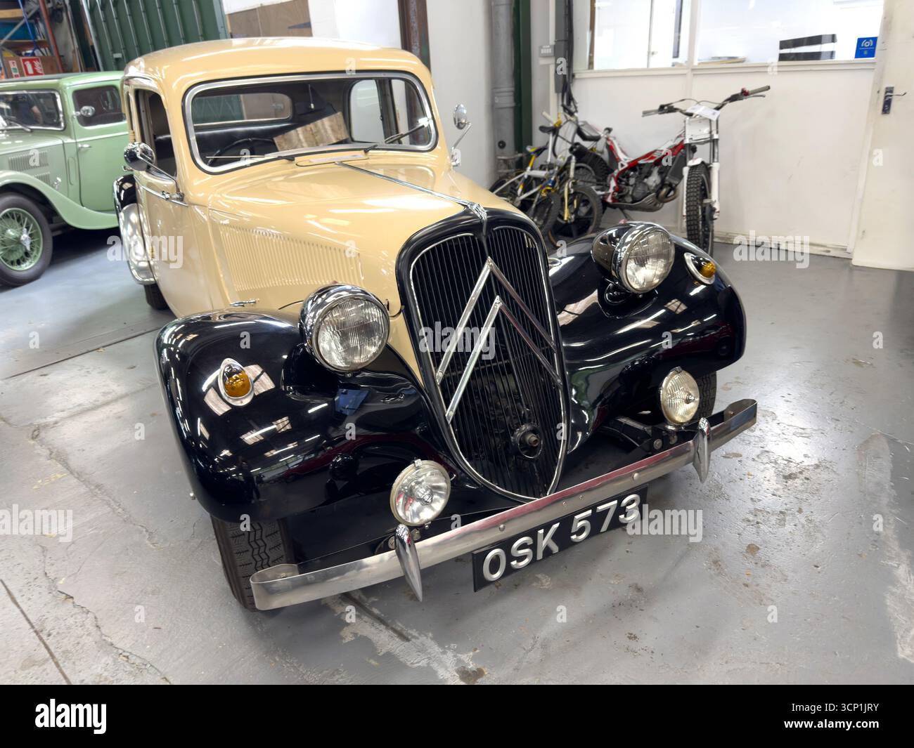 Oldtimer Citroën Traction Avant in einer Garage mit klassischen Fahrzeugen im Hintergrund mit elegantem Design Stockfoto