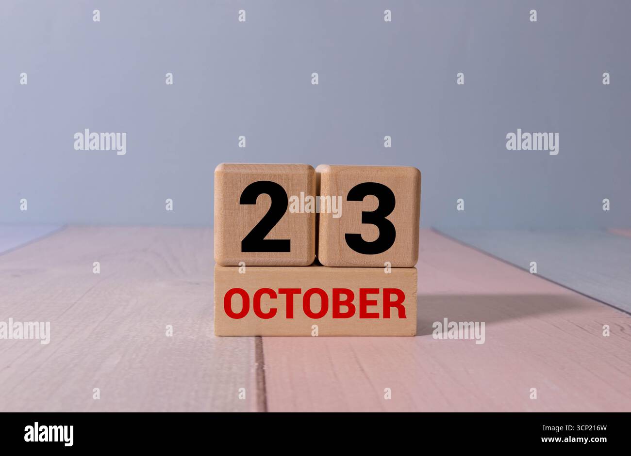 Holzkalender mit Datum 23. oktober und dekorativer Pflanze auf dem Tisch Stockfoto