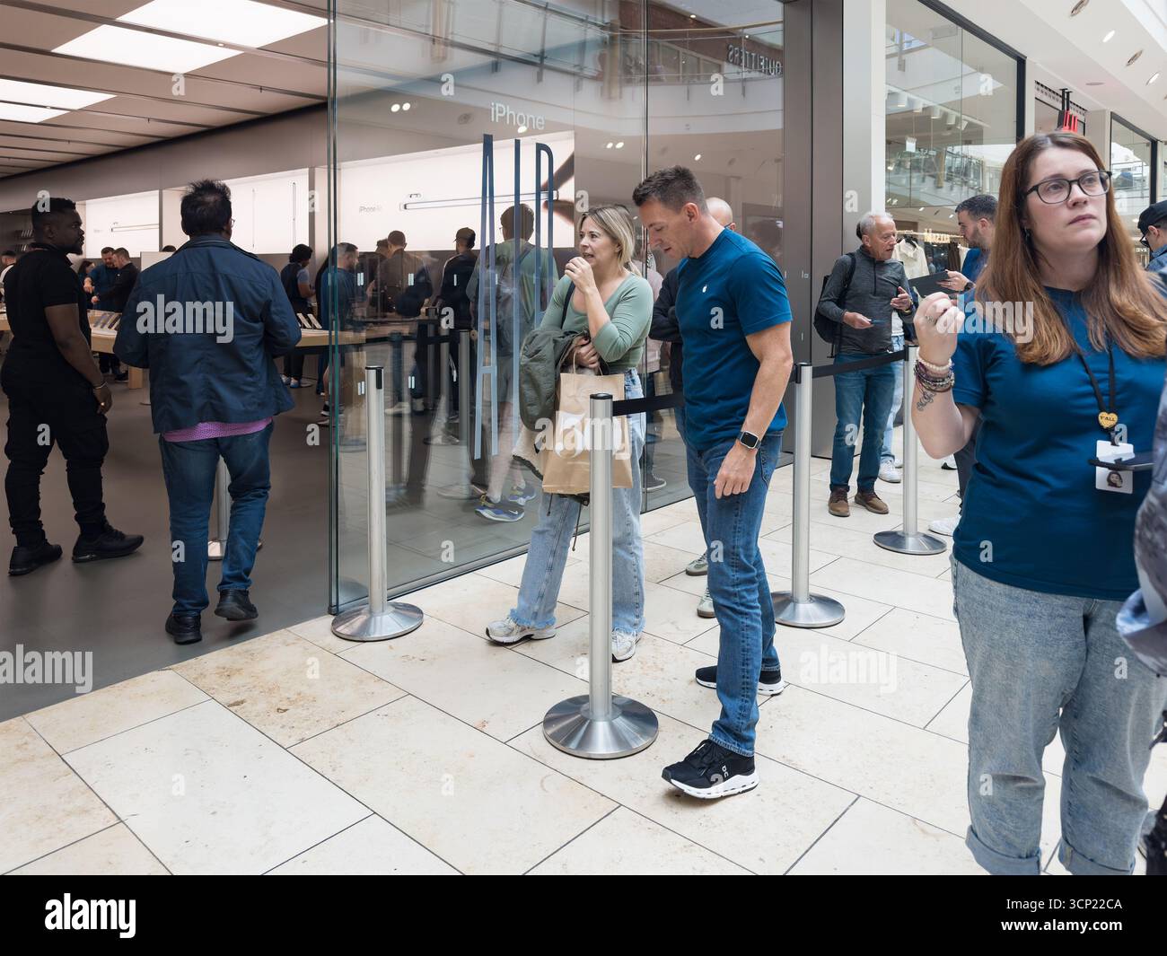 In einem modernen Apple Store in der newcastle metrocentre Shopping Mall warten Leute in der Schlange auf das neue iPhone 17 - Smartphone-aufgenommenes Stockfoto