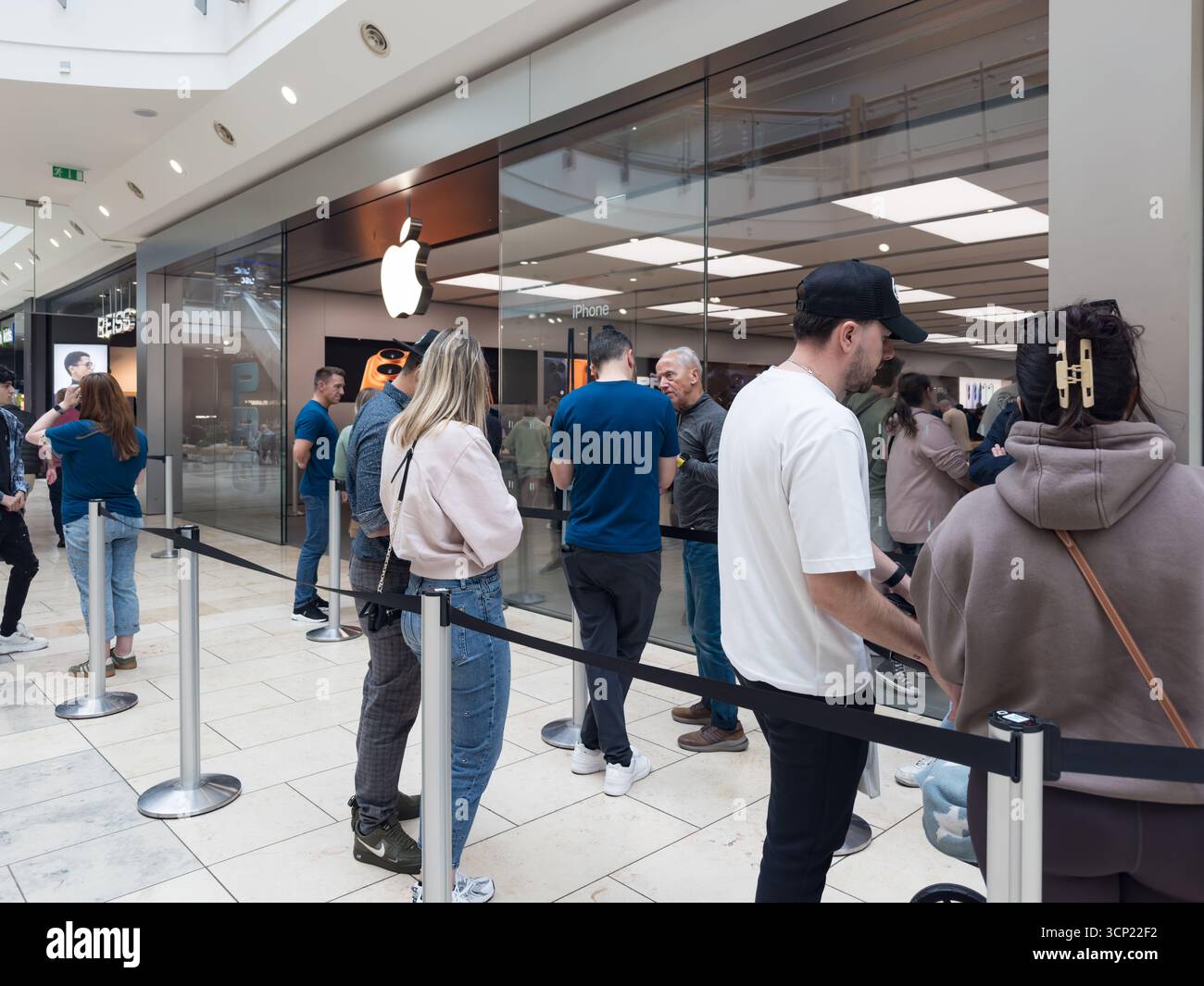 In einem modernen Apple Store in der newcastle metrocentre Shopping Mall warten Leute in der Schlange auf das neue iPhone 17 - Smartphone-aufgenommenes Stockfoto