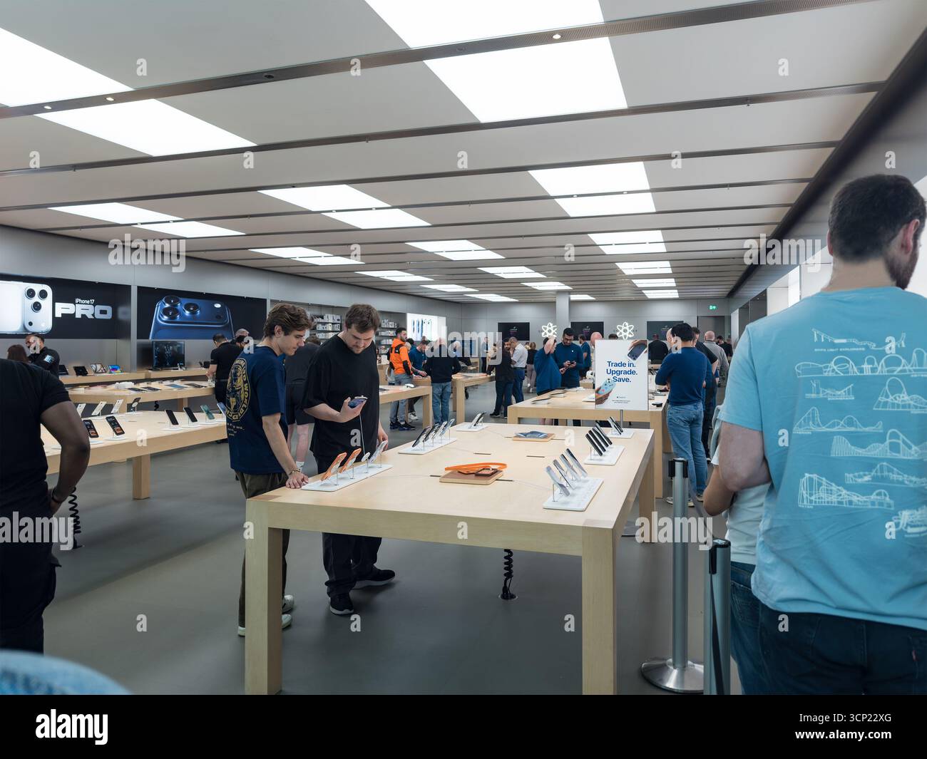 Kunden durchsuchen und testen Geräte in einem geschäftigen, modernen Apple Store mit heller Beleuchtung und elegantem Design Apple newcastle metrocentre - Smartphone-aufgenommenes Stockfoto