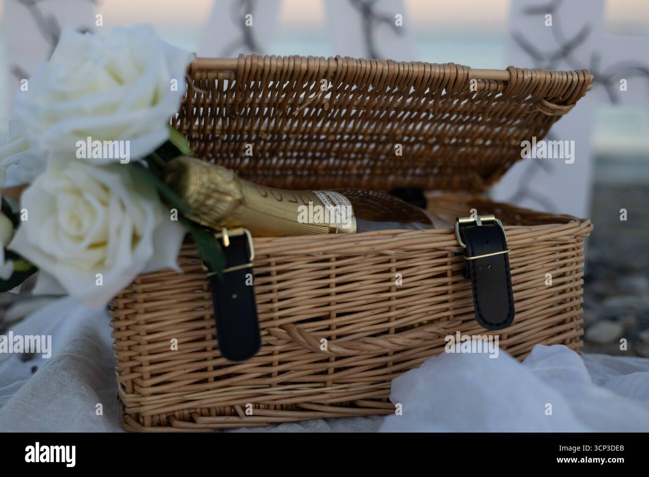 Romantische Stranddekoration mit weißen Rosen im Korb Stockfoto