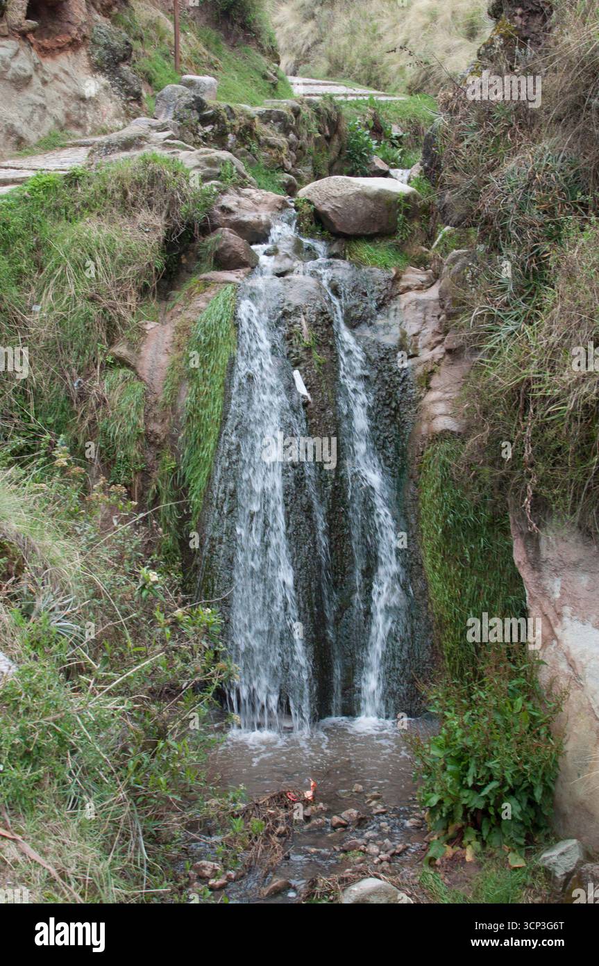 Wasserfall oder kleiner Wasserfall am Eingang zu den Ruinen des Sacsayhuaman Park, einem Bach, der entlang des Weges verläuft. Stockfoto