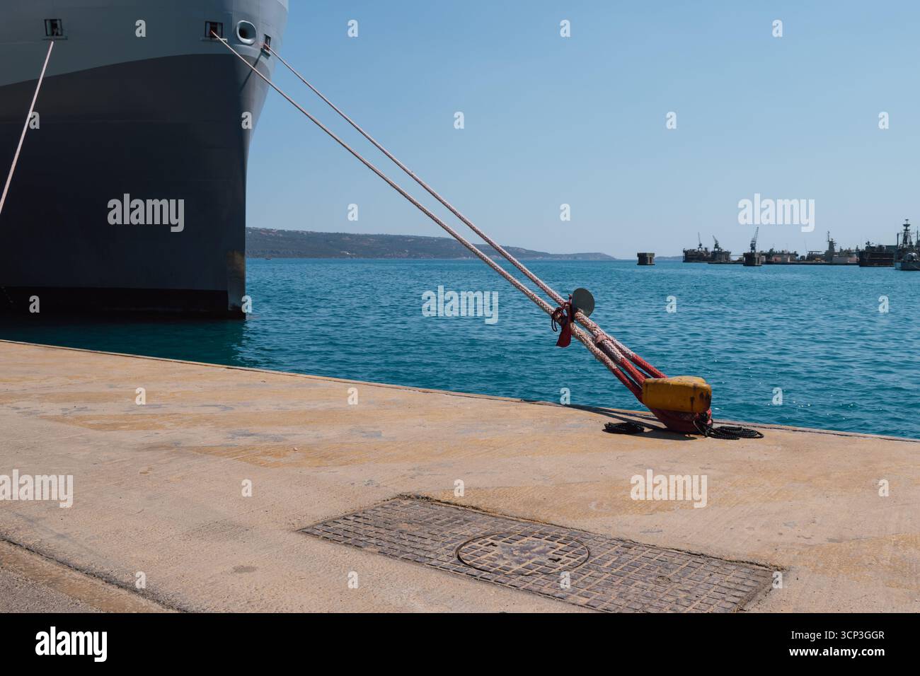 Festmachen eines Schiffes im Hafen mit Festmacherleinen an einem Schiffspoller am Kai Stockfoto