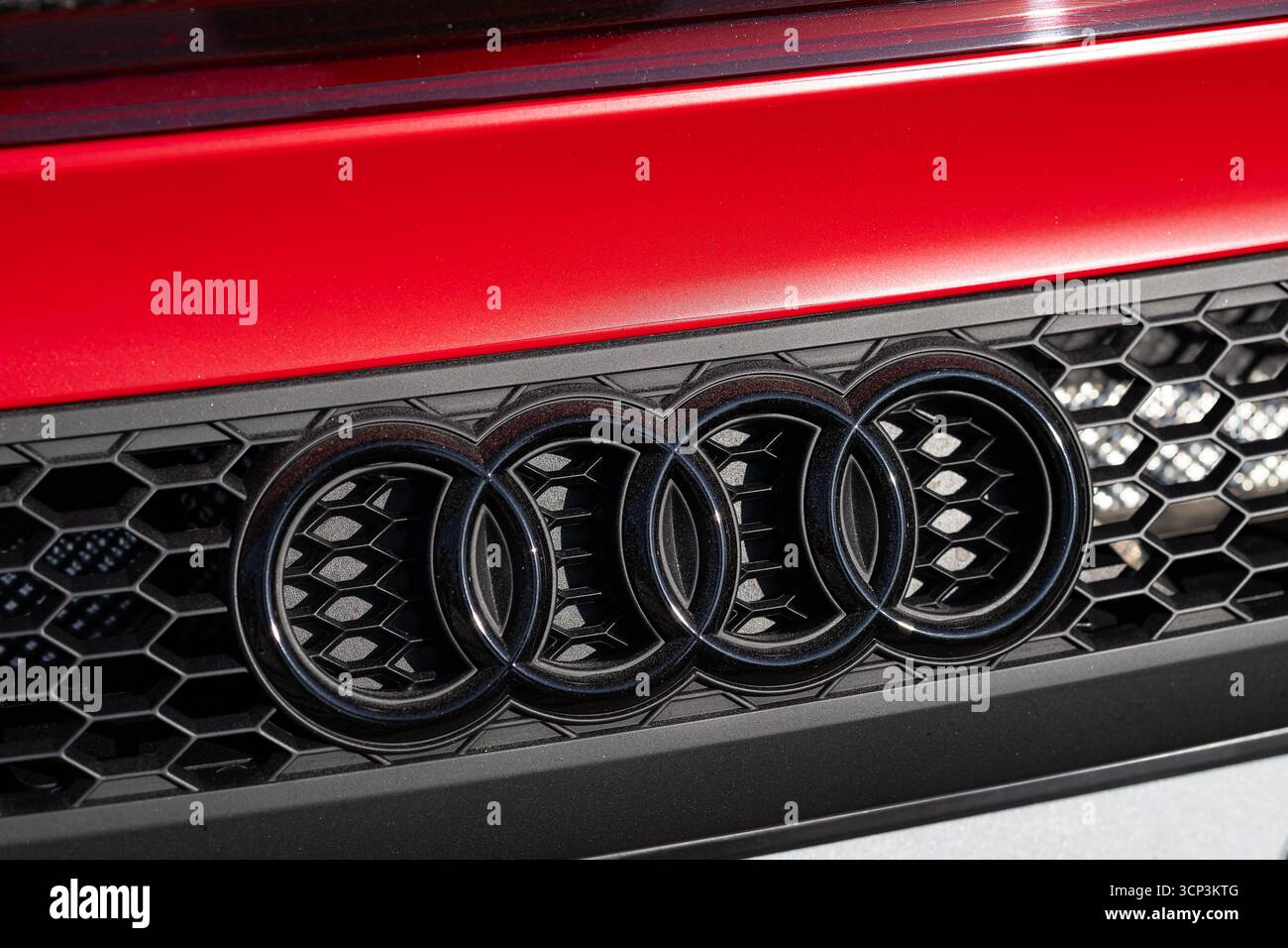 Wroclaw, Polen – 21. Juni 2025: Nahaufnahme des ikonischen Audi-Logos mit vier ineinandergreifenden Ringen am schwarzen Wabengrill eines roten Luxuswagens Stockfoto