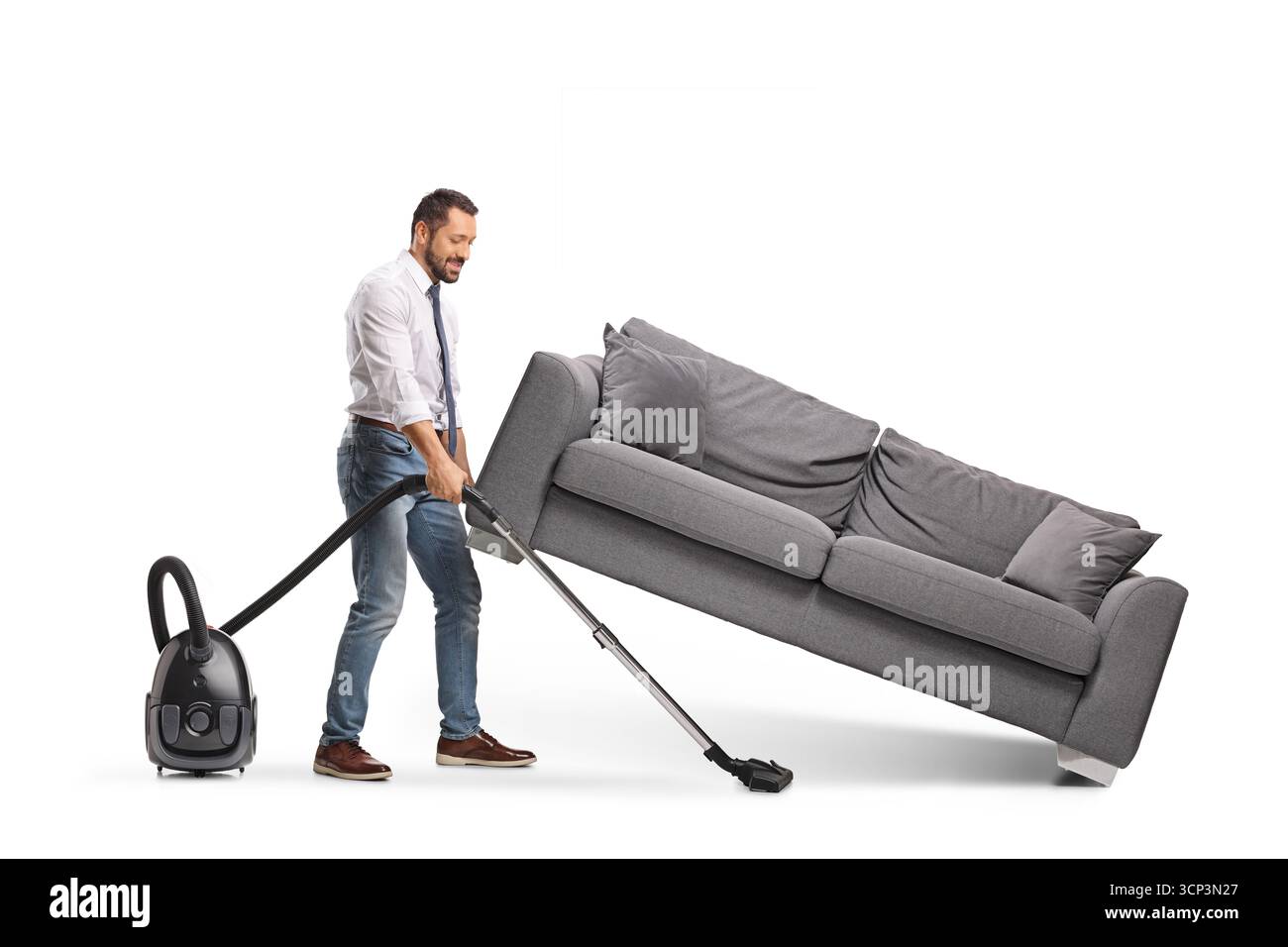 Mann saugt unter einem Sofa, isoliert auf weißem Hintergrund Stockfoto