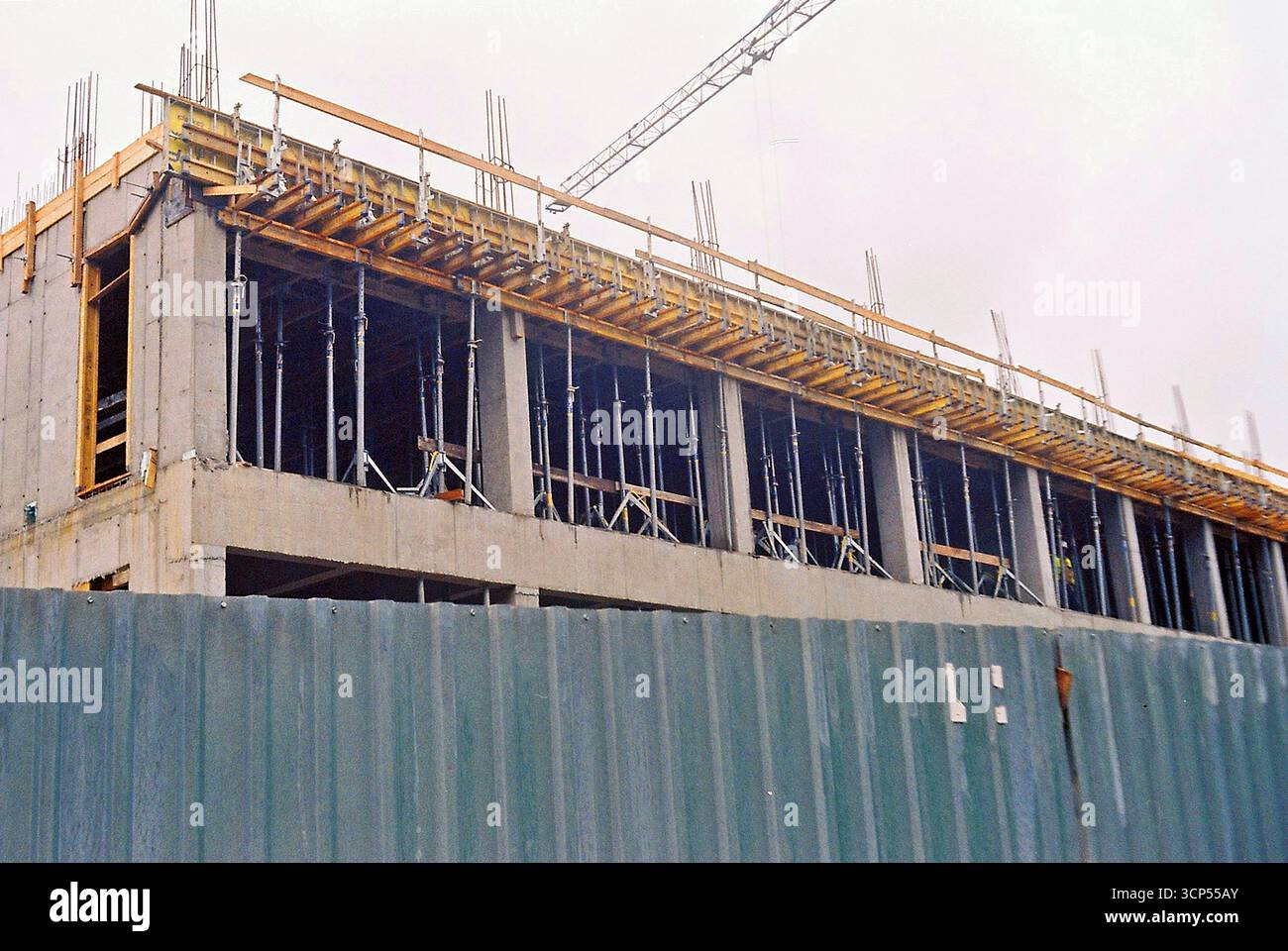 Analoges Archivfoto einer Baustelle von außen mit Zäunen, Schalungen, Beton und Bewehrungskonstruktionen. Stockfoto