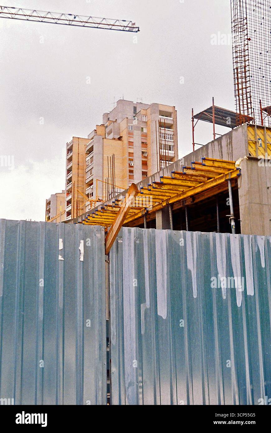 Analoges Archivfoto einer Baustelle von außen mit Zäunen, Schalungen, Beton und Bewehrungskonstruktionen. Stockfoto