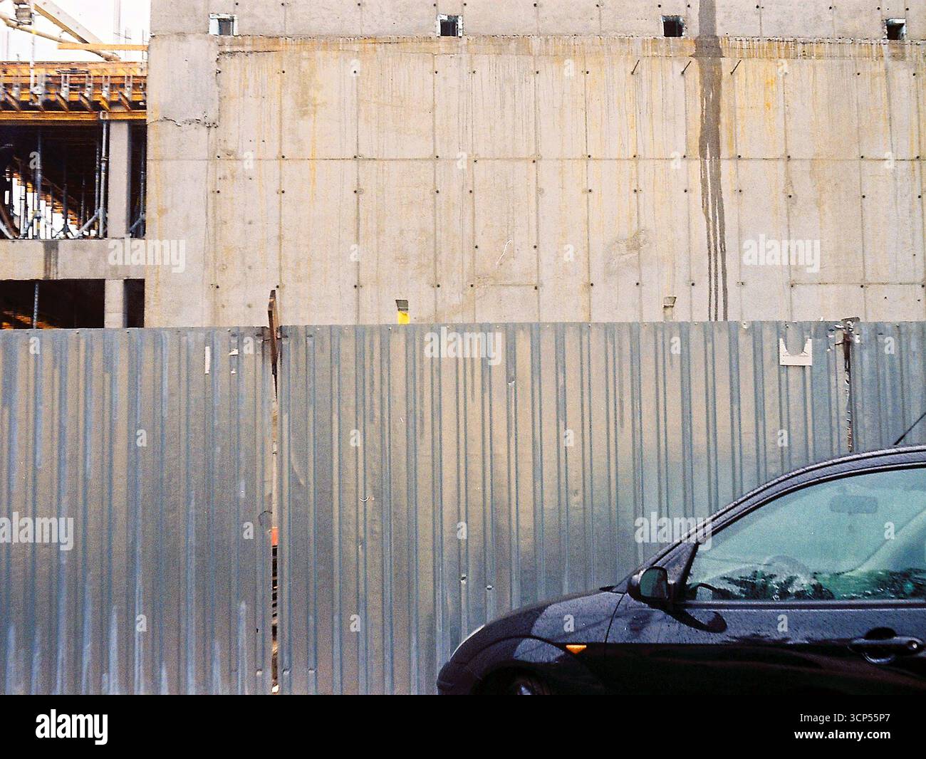 Analoges Archivfoto einer Baustelle von außen mit Zäunen, Schalungen, Beton und Bewehrungskonstruktionen. Stockfoto