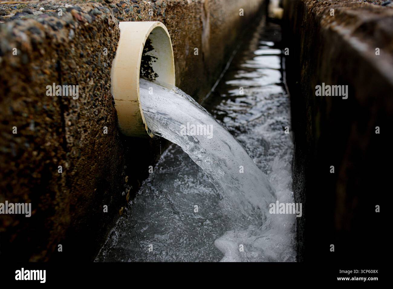 Abwasser aus der industriellen Abflussleitung in die Kanalisation Stockfoto