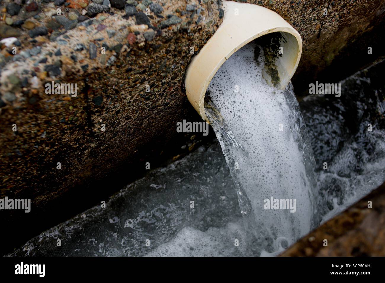 Abwasser aus der industriellen Abflussleitung in die Kanalisation Stockfoto