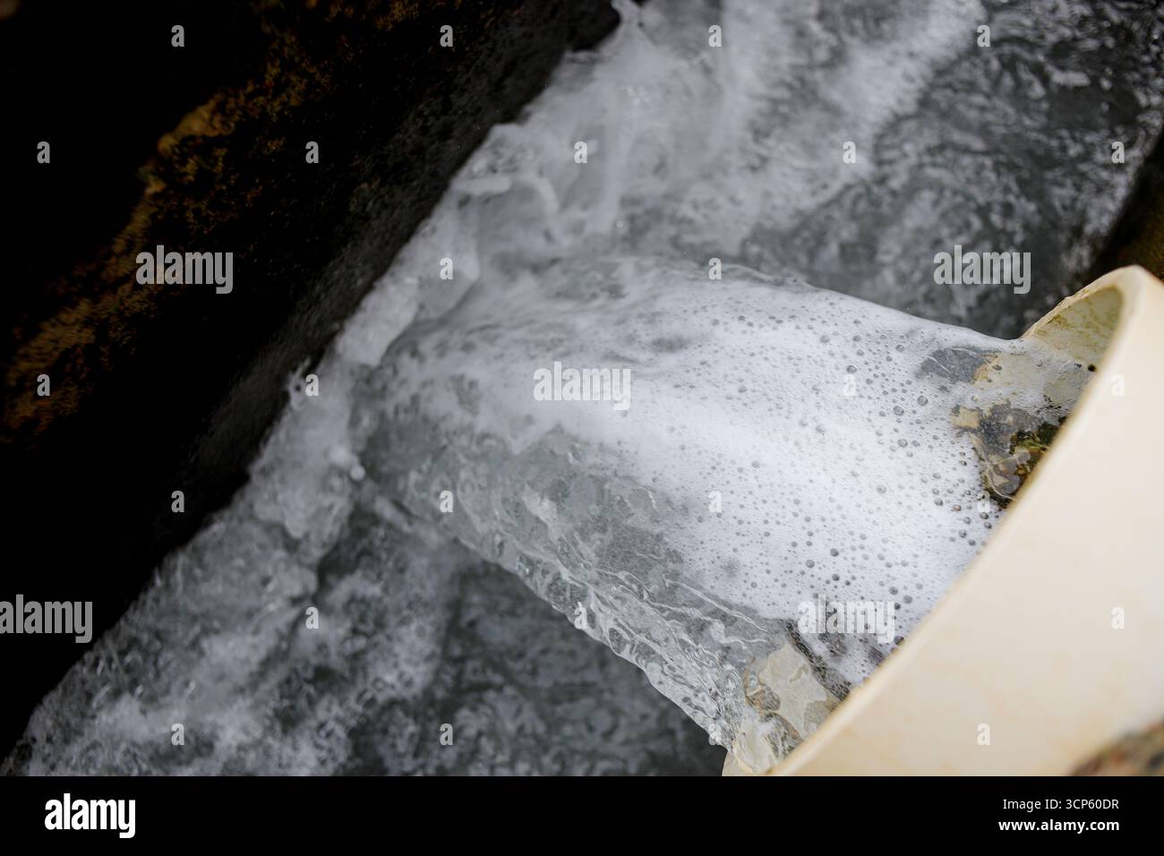 Abwasser aus der industriellen Abflussleitung in die Kanalisation Stockfoto