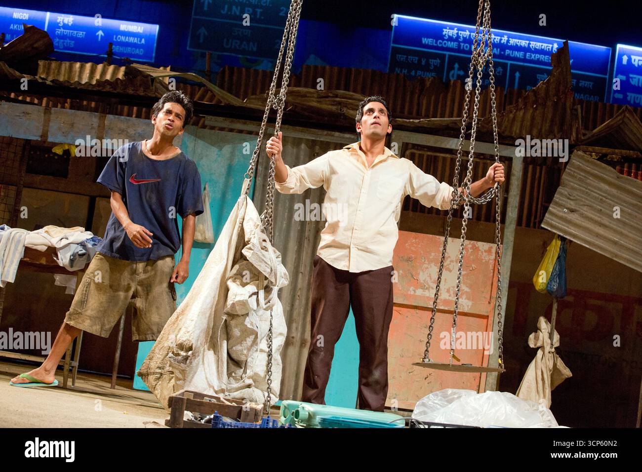 l-r: Hiran Abeysekera (Sunil Sharma), Shane Zaza (Abdul Husain) in BEHIND THE BEAUTIFUL FOREVERS von David Hare im Olivier Theatre, National Theatre (NT), London SE1 18/11/2014, basierend auf dem Buch von Katherine Boo Design: Katrina Lindsay Beleuchtung: Paule Constable Regie: Rufus Norris Stockfoto