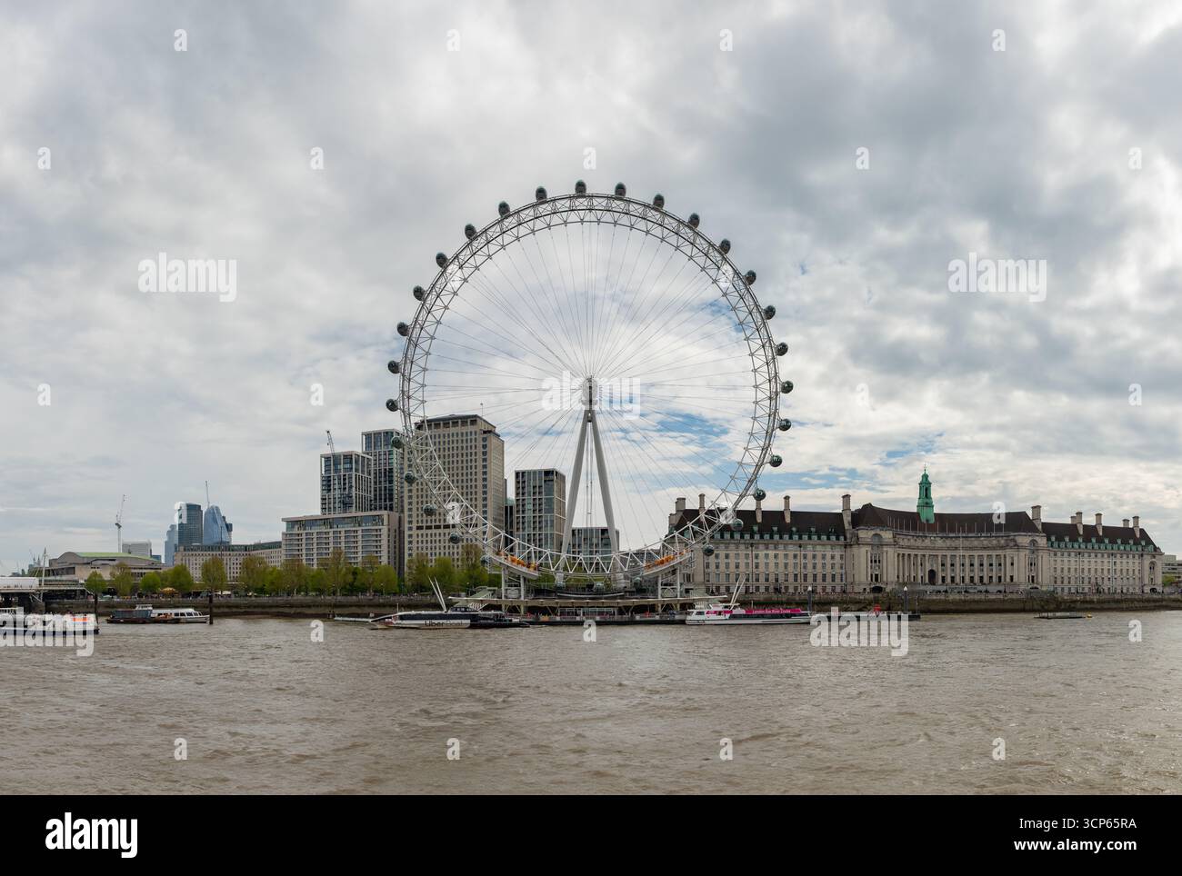 Ein Bild des London Eye, das an einem bewölkten Tag über der Themse gesehen wurde. Stockfoto