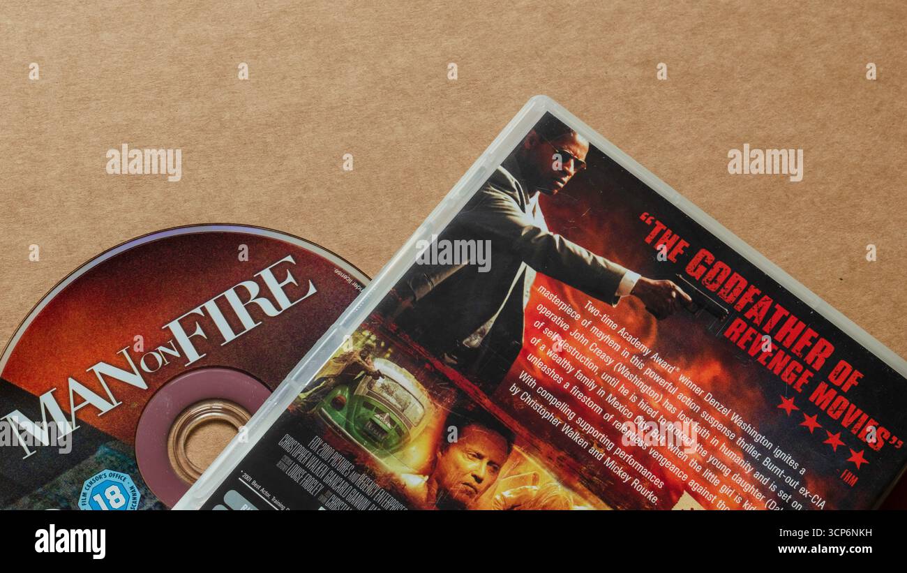 'Man on Fire' DVD-Disc mit rückseitigem Cover mit Filmbeschreibung und FHM-Rezension: 'Der Pate der Revenge Movies', isoliert auf leerem Hintergrund. Stockfoto