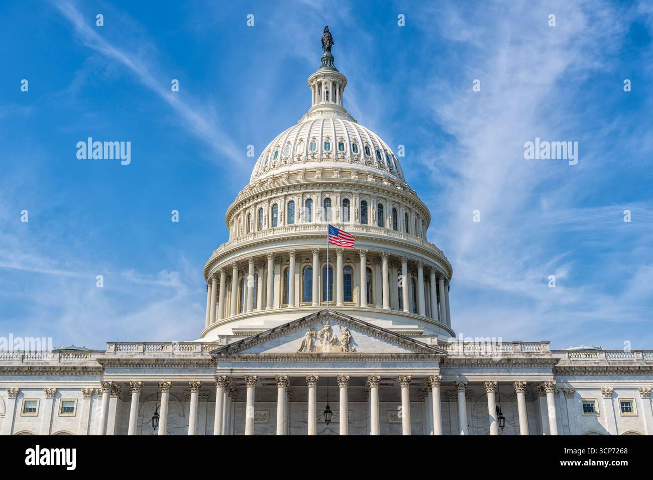 US Capitol Building Dome Washington DC // WASHINGTON DC – die Kuppel des US Capitol Building ist vor einem hellblauen Himmel mit schimmernden Wolken abgebildet. Die ikonische Struktur, ein Symbol der amerikanischen Demokratie, besticht durch klassische Architektur mit korinthischen Säulen und komplizierten Details. Auf der Kuppel steht die Freiheitsstatue, eine Bronzeskulptur, die die Freiheit repräsentiert. Das Capitol Building dient als Versammlungsort für den Kongress der Vereinigten Staaten, in dem sowohl der Senat als auch das Repräsentantenhaus untergebracht sind. Der Bau begann 1793, und er wurde mehrfach erweitert und erneuert Stockfoto