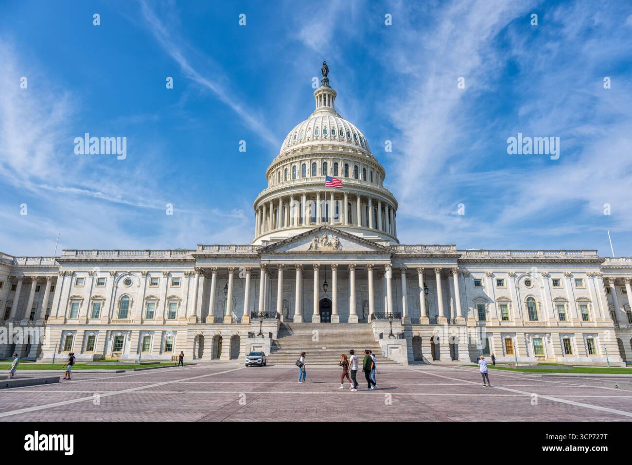 US Capitol Building Washington DC USA // WASHINGTON DC — das Kapitol der Vereinigten Staaten, ein prominentes Wahrzeichen in Washington D.C., ist unter einem hellblauen Himmel mit verstreuten Wolken dargestellt. Diese ikonische Struktur dient als Treffpunkt für den Kongress der Vereinigten Staaten, der aus dem Senat und dem Repräsentantenhaus besteht. Die markante Kuppel ist ein Symbol der amerikanischen Demokratie und des nationalen Stolzes. Die Architektur des Gebäudes zeigt neoklassizistische Designelemente, die seine historische Bedeutung und Pracht widerspiegeln. Das U.S. Capitol befindet sich am östlichen Ende der National Mall, einem V Stockfoto