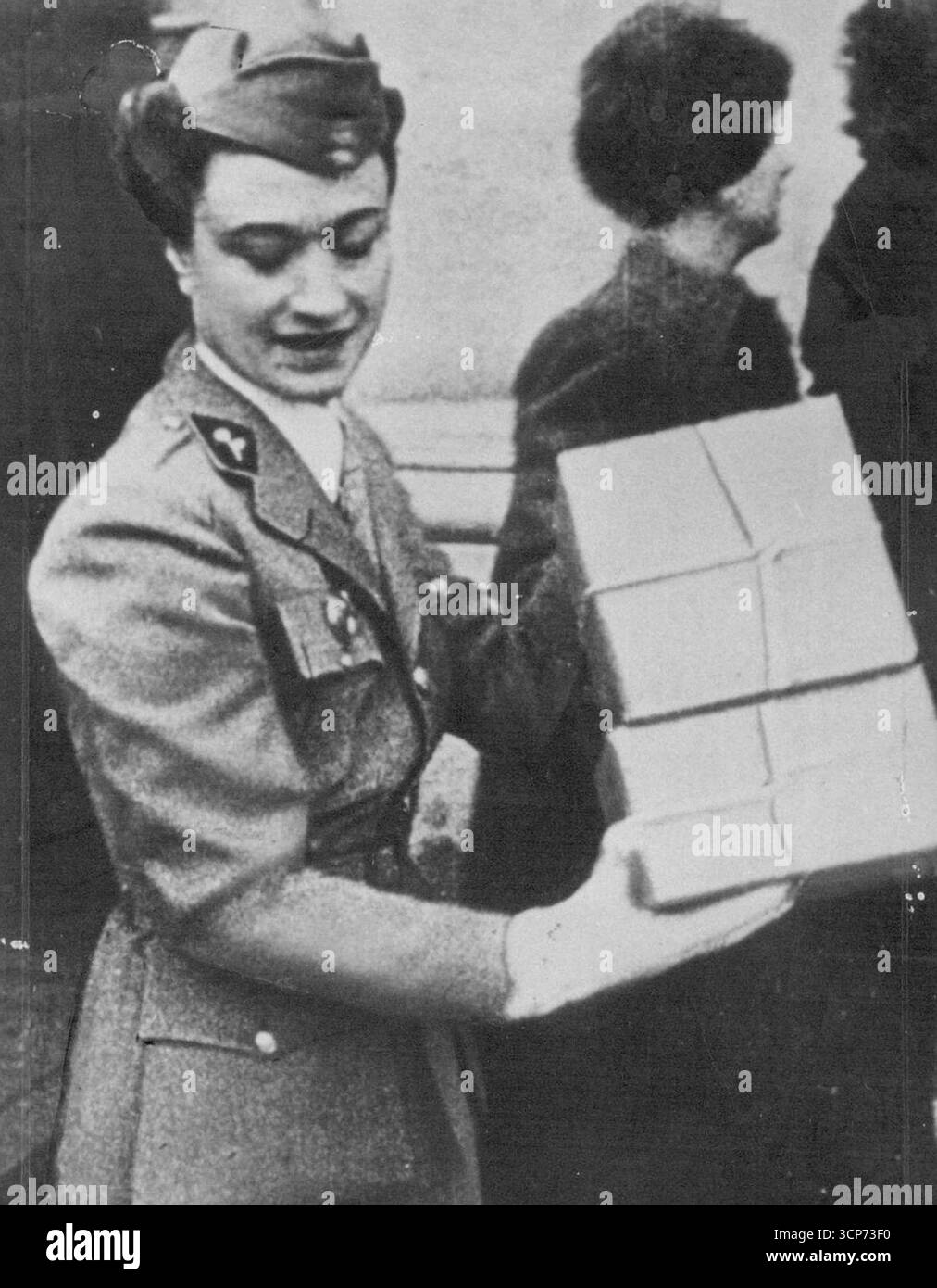Herzogin von Windsor (L-R) oben und unten in Paris gezeigt Laden von Weihnachtsgeschenken in einen LKW zur Verteilung an französische Soldaten. Sie wird mehrere Pakete übergeben, dreht sich dann um und legt sie in den Heck of Truck, und ruft über ihre Schulter für eine weitere Armvoll Bundles. 11. Juli 1954. Stockfoto