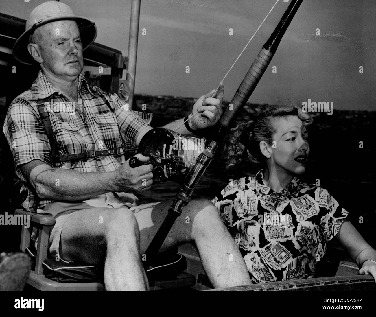 Dan Daly argumentiert, dass A Pretty einem Verkäufer hilft. Marie Johnson hilft ihm dabei, Wildfischen zu verkaufen. März 1952. Stockfoto