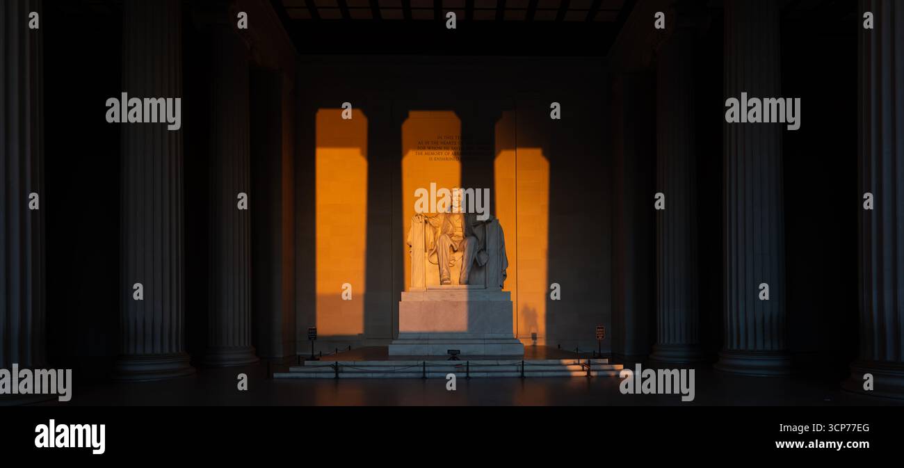 Lincoln Memorial Statue Washington DC Vernal Equinox Sonnenaufgang // WASHINGTON DC — die Lincoln Memorial Statue wird während der Frühlingstaginox von der aufgehenden Sonne beleuchtet, wenn die Sonne direkt im Osten aufgeht. An einem klaren Morgen scheint das Sonnenlicht direkt in die Hauptkammer und auf die monumentale Statue von Abraham Lincoln. Das Denkmal, das dem 16. Präsidenten der Vereinigten Staaten gewidmet ist, ist ein prominentes Wahrzeichen der National Mall. Entworfen vom Architekten Henry Bacon, wurde es 1922 fertiggestellt. Die Statue selbst wurde von Daniel Chester French gestaltet. Stockfoto
