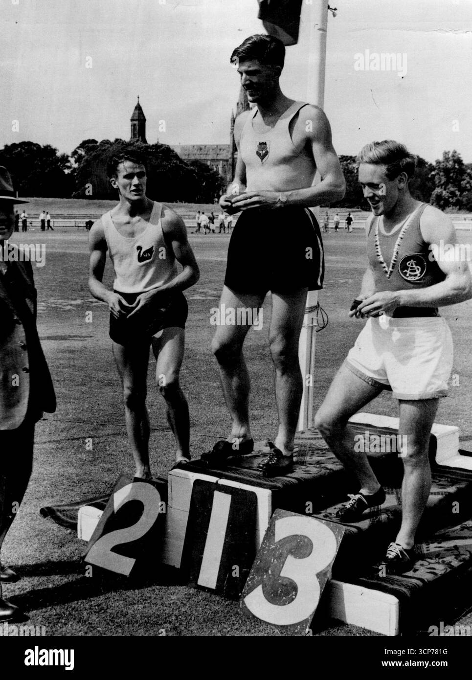 Bill de Gruchy (links) blickt sehnsüchtig auf John Treloar, der bei den letzten australischen Meisterschaften den ersten Platz bei den Siegen belegte. A.K. Gordon (rechts) war Dritter. De Gruchy (links) blickt bewundernswert auf den NSW-Star John Treloar beim Sieg in Adelaide bei den letzten australischen Meisterschaften. Dezember 1950. Stockfoto