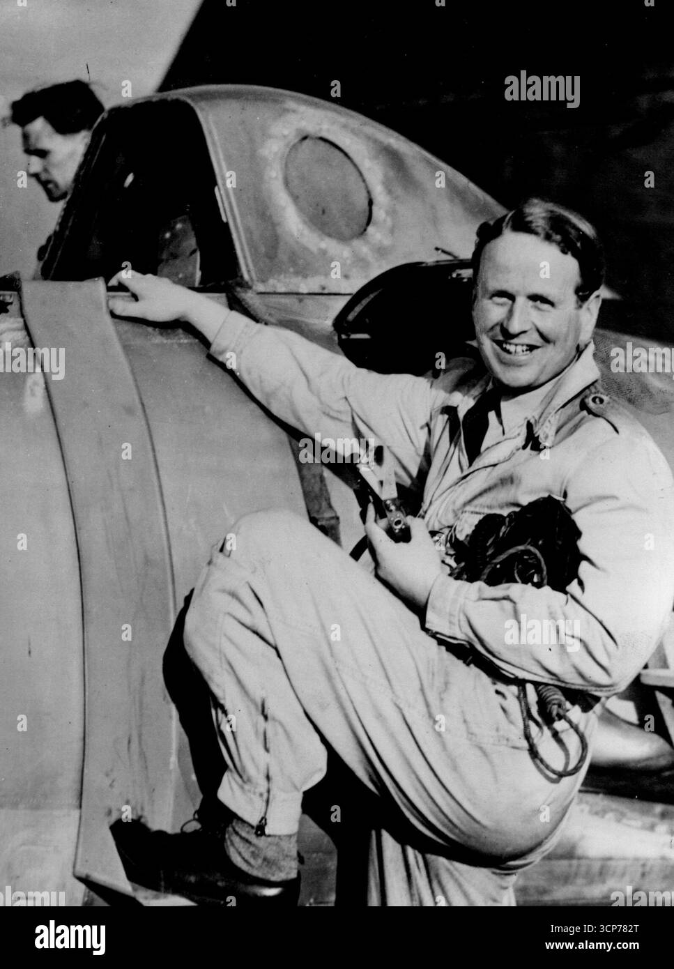 British Jet Plane Stellt Neuen Höhenrekord Auf. Über 18 Meilen hoch -- Gruppenkapitäne John Cunningham (Distinguished Service Order: Distinguished Flying Cross) klettert in das versiegelte Cockpit des 'Vampire' für den Rekordflug. Dank des unter Druck stehenden Cockpits konnte Cunningham nur mit einem einfachen Overall tragen – im Gegensatz zum aufwändigen Anzug, der erst vor wenigen Jahren verwendet wurde. Ein de Havilland 'Ghost Vampire'-Jet-Jäger, der von dem während des Krieges eingesetzten Nachtjäger-Ass Captain John Cunningham gesteuert wurde, stellte einen neuen Weltrekord von 59, 492 ft (18.133 m) auf. März 1948. Stockfoto