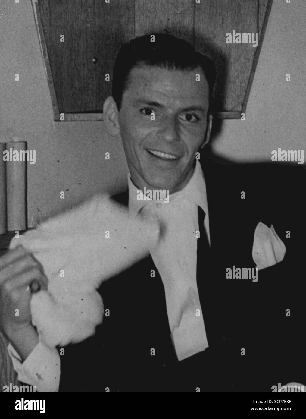 Swoon King ruht aus seinen Liebesbeziehungen London Mobs Frank Sinatra müde, aber Happy Frank Sinatra sinkt gestern Abend wieder auf einer Couch in seiner Garderobe im Londoner Palladium Theatre. Dieser King of the Swoon Producers stand so lange auf der Bühne, dass er mitten in seiner Aufführung eine Tasse Tee trank und dann weitere seiner seelenvollen Liebesballaden sang . Er will bis gegen Mitternacht singen. Sowohl vor als auch nach dem Auftritt wurde er von Bewunderern gemobbt. Zusätzliche Polizisten waren im Dienst, aber sie hatten große Schwierigkeiten, die Menschenmassen zu kontrollieren. Juli 1950. (Foto: Paul Popper Ltd.) Stockfoto