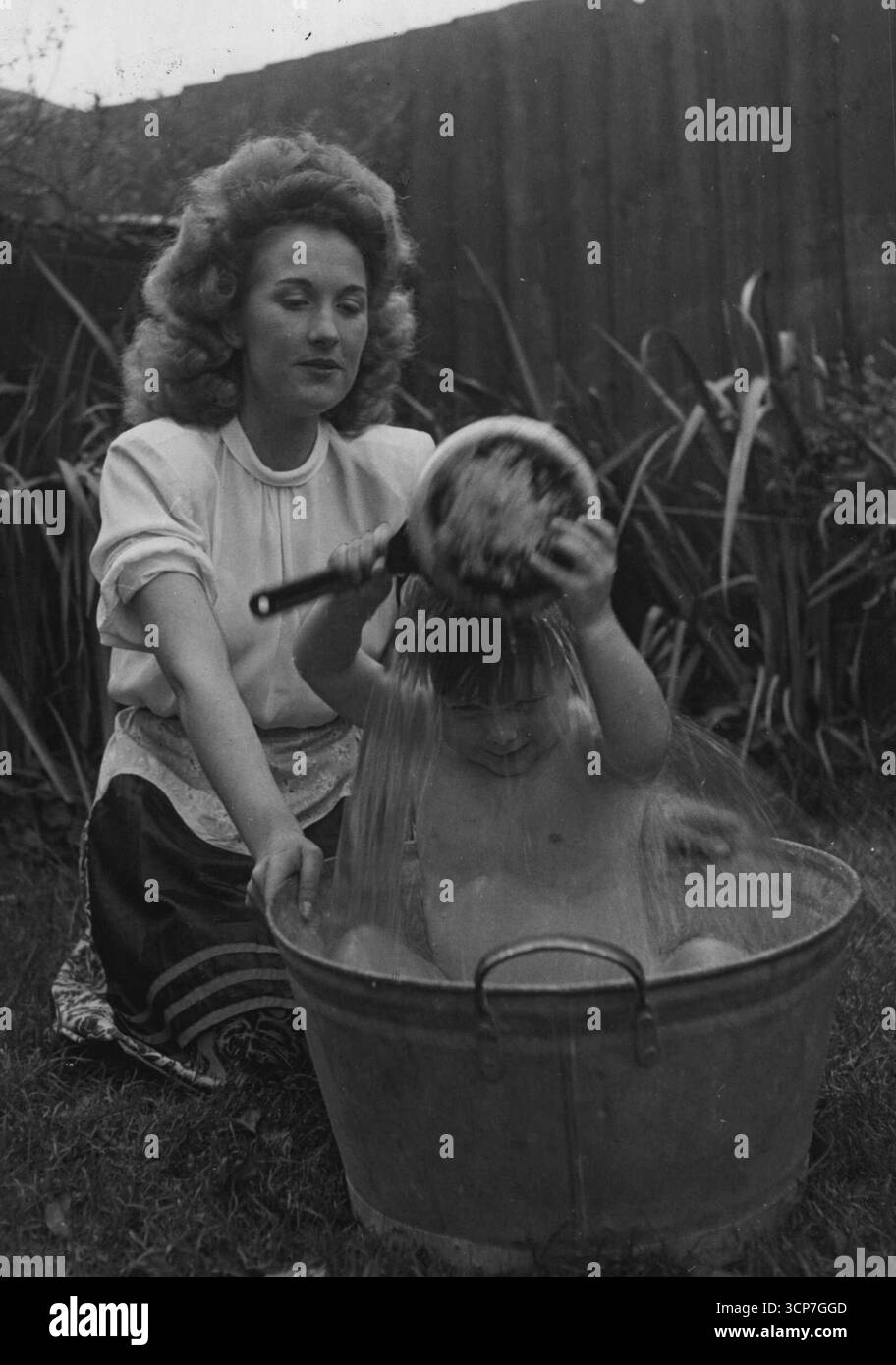 Kälte Eines Lebens -- um sechs Uhr jeden Abend John Anthony Salisbury, zwei Jahre, fünf Monate, schlüpft in den Garten seiner Shoeburyness, Essex, nach Hause und nimmt eine eiskalte offene-ein ***** Bad - so. Er macht es, seit er einen Monat alt war, und an den dunklen Winterabenden tut er es immer noch - durch das Licht einer Fahrradlampe. Seine Mutter, Mrs. Joyce Salisbury, 2b, beobachtet ihn, sagt: ich will, dass John hart und hart ist, wenn er erwachsen ist. Er hatte nie eine Erkältung oder eine Krankheit. John kann laufen und reden und ist immer voller Bohnen, aber er hasst heißes Wasser. "Er wäscht einfach nicht sein h Stockfoto