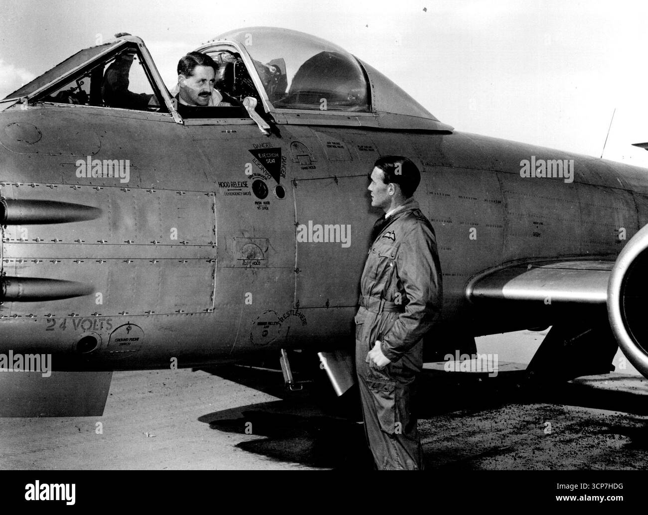 Richard Cresswell, Kommandeur der australischen 77 (F)-Geschwader, nimmt das Cockpit eines Meteors oder Jet und erhält vor dem Start die Anweisungen von RAF-Ausbilder Flt/Lt Maxwell Scannell in letzter Minute. FLT/Lt Scannell leitet das Team von RAF-Flugzeugen, die nach Japan kamen, um dem Geschwader bei der Umstellung vom konventionellen kolbenmotorisierten Flughafen zu helfen. April 1951. Stockfoto