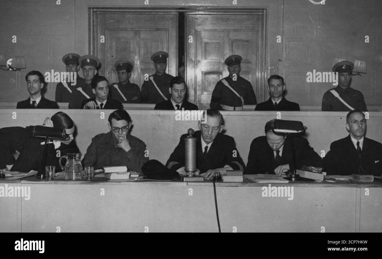 Die Gefangenen im Dock (oberste Reihe) unter der Wache von M.P.S. Jeder befindet sich ganz links. Tote Männer nicht ***** Aber die Opfer von Lieutenant Commander Heinz Ech waren nicht tot genug. Er steht in Hamburg vor Gericht wegen Maschine ***** Die Überlebenden eines britischen Schiffes und werfen Hand Grand nach Osten. Einige der Männer, die nach 25 Tagen auf Flößen aufgegriffen wurden, waren am Leben, um vor Gericht zu sein, um gegen ihn auszusagen. November 1945. (Foto mit Spiegelfunktionen). Stockfoto