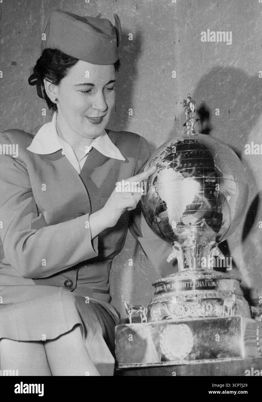 Grand National Crowds will U.S. Horse - Race TrophyThe £3.000 Washington International Horse-Race Trophy - eine 28-Zoll-Silberkugel - wird von der Stewardess Helen Sullivan von Pan American Airways am Flughafen Idlewild, New York, untersucht, bevor sie nach Großbritannien geflogen wird. Der Globus, der letztes Jahr von einem britischen Pferd, Mr. Robert Boucher's Wilwyn, in Amerika gewonnen wurde, geht auf Europatour. Es ist die erste amerikanische Turf-Trophäe, die zur Ausstellung ins Ausland geschickt wurde. Die Trophäe wird den Besuchern der Grand National Crowds in Aintree, Liverpool, gezeigt. Danach geht es nach Newmarket (für die Guineas), Epsom (für das Derby) und Stockfoto