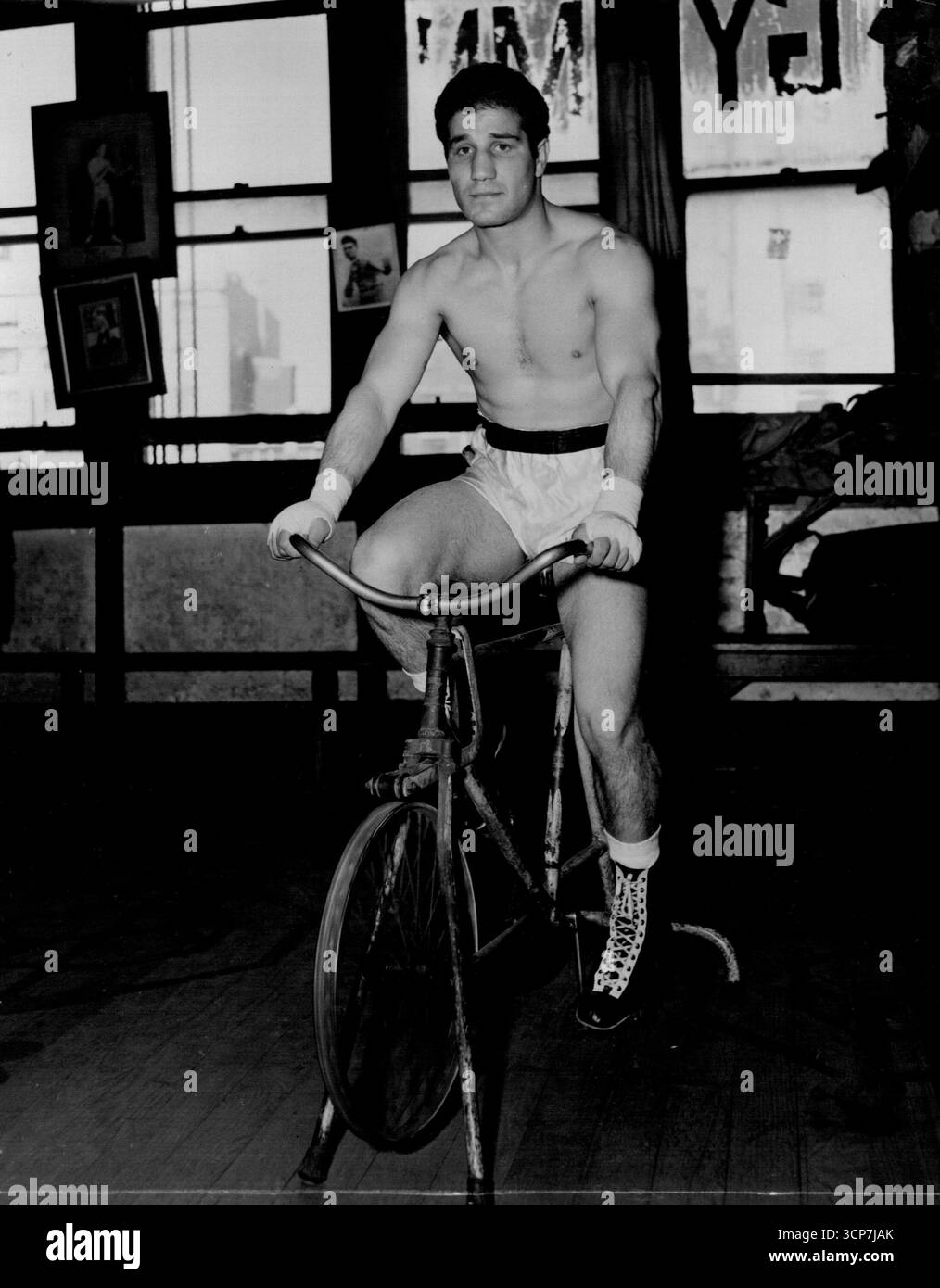 Luigi Coluzzi, der am Montagabend im Stadion gegen Don Johnson kämpft, hält sich auf einen Turnhalle-Zyklus. Oktober 1954. Stockfoto