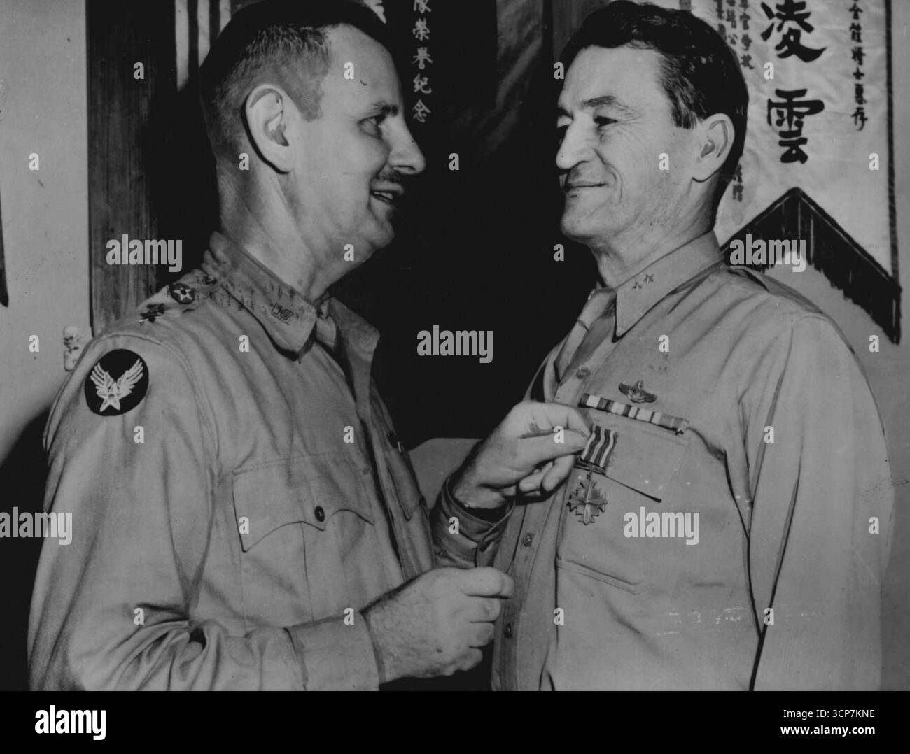 Chennault erhält das Distinguished Flying CrossMajor General Claire L. Chennault (rechts), Kommandeur der 14th U.S. Army Air Force, erhält das Distinguished Flying Cross von Major General George L. Stratemeyer, Kommandeur der US Army Air Forces in China, Burma und Indien General Chennault wurde für seinen hervorragenden Dienst gegen die Japaner in den drei Kommandos, die er in China innehatte, zitiert. Er diente zunächst als Kommandeur der American Volunteer Group, den „Flying Tigers“, die vor dem Kriegseintritt der USA gegen die Japaner kämpften, dann als Kommandeur der China Air Task Force der US Army, b Stockfoto