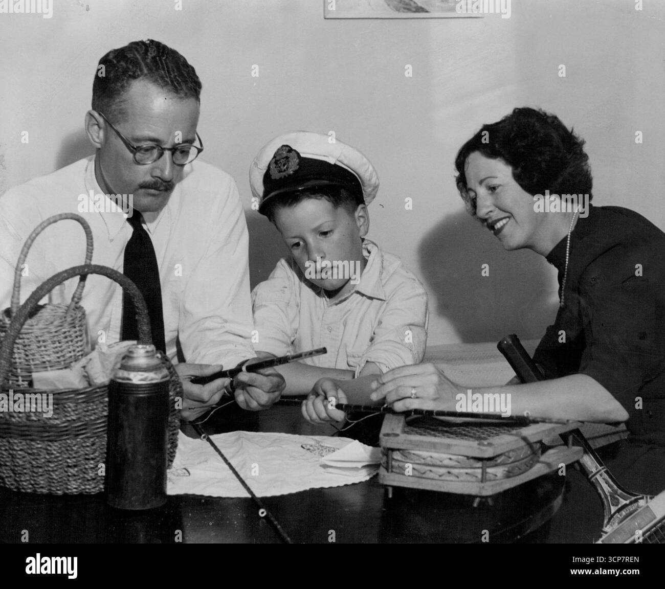 Letzte Nacht in einem nahe gelegenen Strandresort bereiteten Major Charles Cousens und seine Frau und sein 7-jähriger Sohn Robert ihre Urlaubswünsche vor und machten sich bereit, einen ruhigen Urlaub zu verbringen, nachdem der Generalstaatsanwalt entschieden hatte, nicht mit den Vorwürfen des Verrats gegen ihn fortzufahren. Sie reparierten die Ruten und Angelschlangen, bereiteten die Tennisschläger und bereiteten den Picknickkorb vor. Nicht die ganze Zeit verbringen Sie mit dem Urlaub, denn Major Cousens ist auch auf der Hausjagd und wird einige Zeit auf der Suche nach einem Zuhause verbringen, in dem Sie leben können. November 1946. (Foto: Frederick John Halmarick/Fairfax Media). Stockfoto