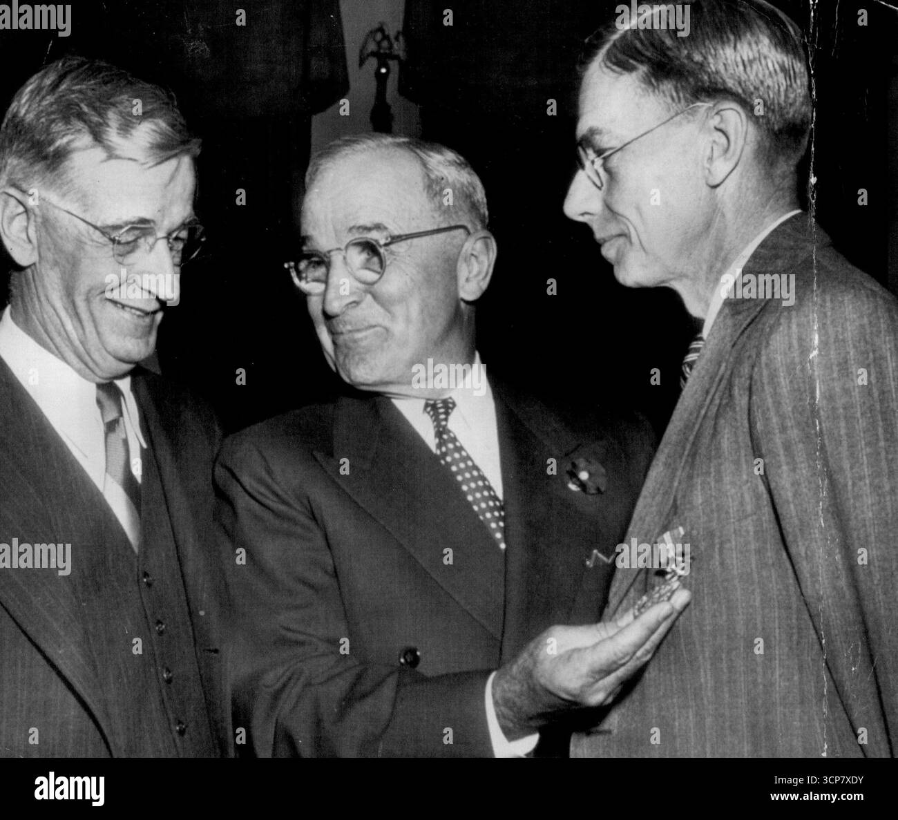 Präsident schmückt Wissenschaftler - Präsident Truman grinst, als er mit dem Eichenblatt-Cluster, den er Dr. James Bryant Conant (rechts) in ***** überreichte, Medaille für Verdienste ausweist Hauszeremonie heute. Er verlieh die gleichen Auszeichnungen auch Dr. Vannevar Bush (links). Auszeichnungen ***** Für ihre Atomforschung. Forschung belohnt. Präsident Truman vergibt Medaillen für Verdienste mit Eichenblatt-Clustern an Dr. James B. Conant (rechts) und Dr. Vannevar Bush für ihre Dienste in der Atomforschung. Juni 1948. Stockfoto