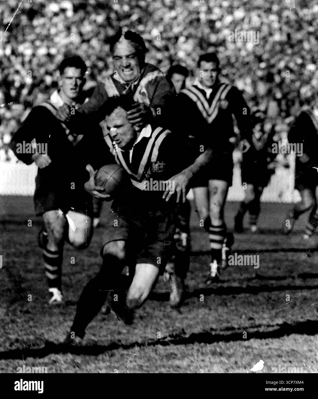 Der australische Kapitän Clive Churchill stürzt sich in den Ligatest, um den Händen des französischen Stürmers Pambrun zu entkommen. Juni 1955. Stockfoto