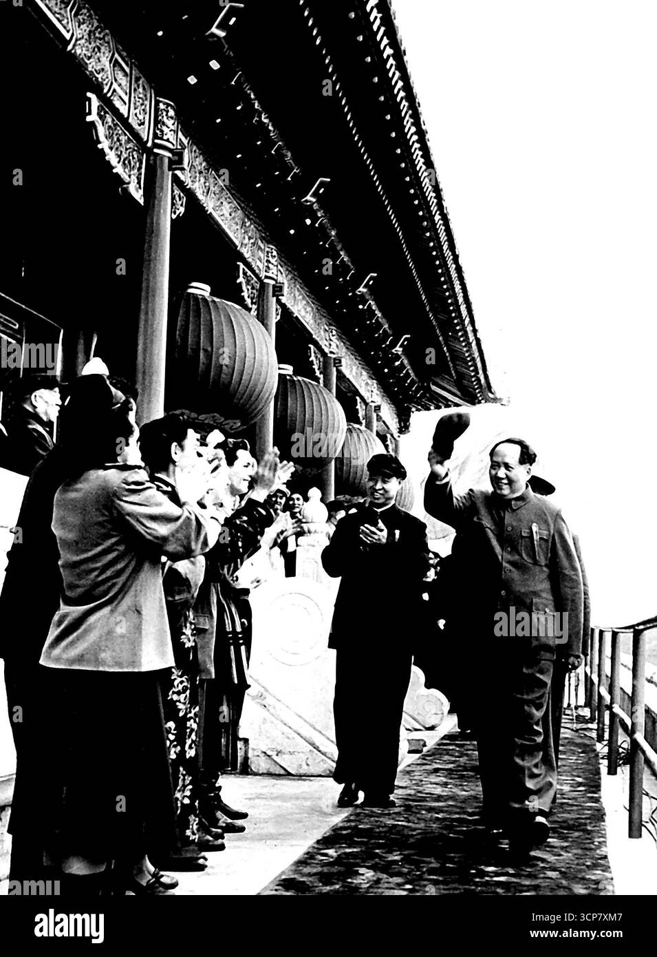 Mai 1953, Mao TSE-Tung zieht in Peking seine Kappe ab -- Mao TSE-tung, Vorsitzender des Zentralen Volksregierungsrates von China, lächelt herzlich, als er den Rezensionsstand auf dem Tien an Men Square in Peking betritt, wo traditionell die Maiparaden des Roten Chinas stattfinden. Im Vordergrund, links, applaudieren Mitglieder des Staatlichen Lieder- und Tanzensembles Mazewaze dem chinesischen Führer. Links, hinter Mao TSE-tung, steht der stellvertretende Vorsitzende Liu Shao-Chi. Mai 1953. (Foto mit Kamerapresse). Stockfoto