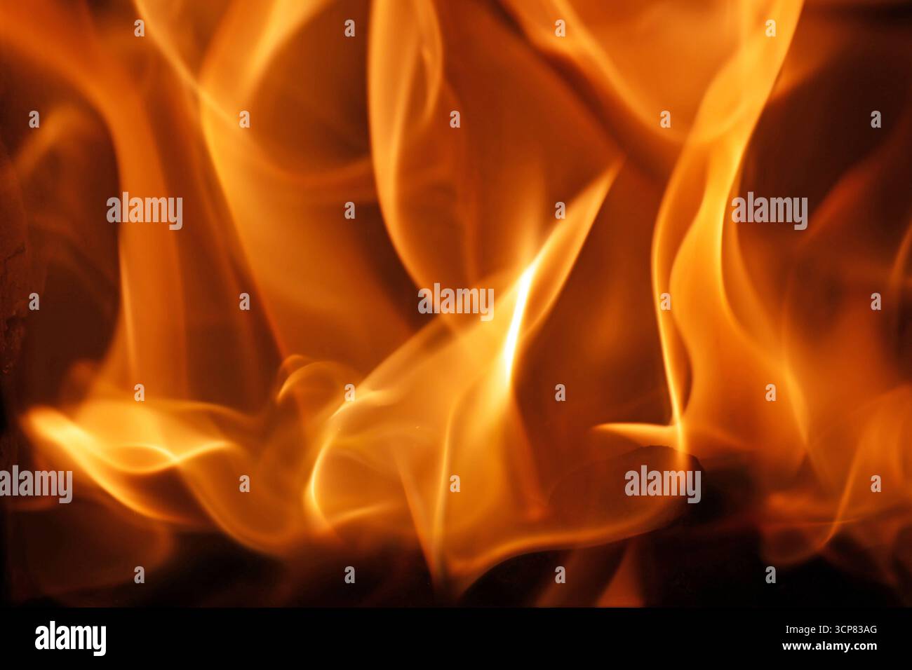 Fossile Brennstoffe Blick in die Feuerung mit Flammen von einem Kachelofen *** fossile Brennstoffe Blick in den Ofen mit Flammen aus einem Kachelofen Stockfoto
