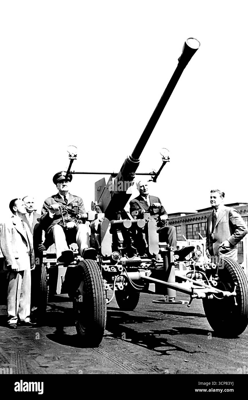 Die Armee erhält die ersten 40-Millimeter-Flugabwehrkanonen Akron, O. - Brigadegeneral Charles T. Harris (in Uniform), stellvertretender Chef des Ordnance Department, und John W. Thomas, Präsident der Firestone Company, sehen eine der ersten 40-Millimeter-Flugabwehrkanonen vom Typ Bofors, die in den USA gebaut wurden Harvey S. Firestone Jr. (ganz links) und Kongressabgeordneter Dow Harter, Mitglied des House Military Affairs Committee, schauen links. Die Waffe wurde der Armee in Akron von der Firestone Tire and Rubber Company geliefert, die die Geschützwagen für die von der Chrysler Corp. Gebauten Waffen herstellt 1. Juli Stockfoto