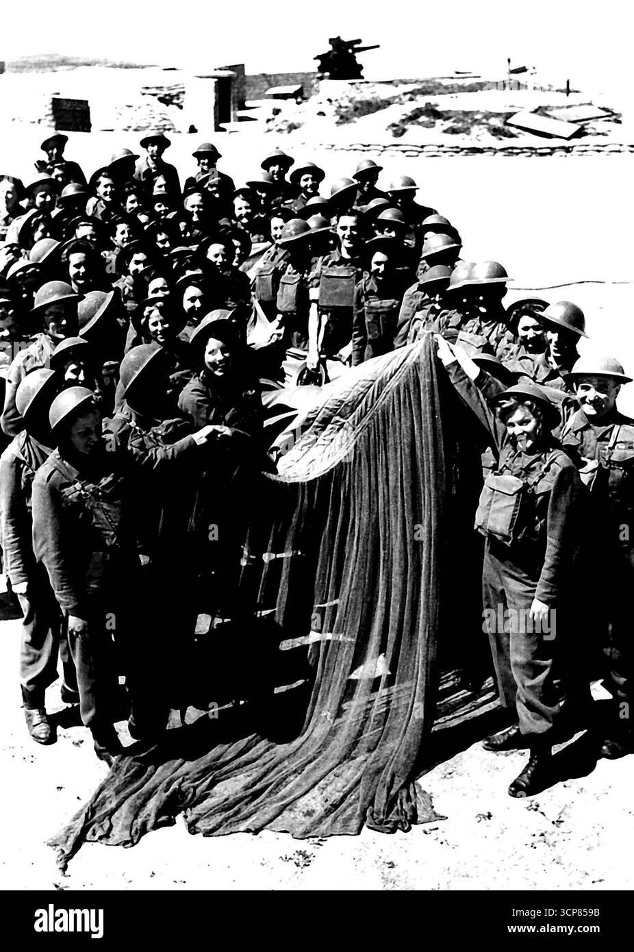 Übungslager für A.A. Mädchen - Männer und Mädchen von A. Befehl mit dem beschädigten „Leeve“, den sie erfolgreich heruntergebracht haben. Einige der Mädchen, die sich für die A.A-Niederlassung der A.T.S. entschieden haben, werden in einem gemischten schweren Anti-Aircraft-Übungslager in East Anglia ausgebildet. Ihre Aufgaben sind es, sich nähernde feindliche Flugzeuge zu erkennen und die Höhe und Reichweite des Ziels zu finden. Zu diesem Zweck werden sie geschult, mit Hilfe von Flugzeugen, die „Sleeve“-Ziele schleppen, genau zu sein, und die hervorragende Leistung, die sie aufgelegt haben, hat der von Männern, die die gleiche Arbeit tun, gleichgesetzt. June25, 1942. (Foto von FOX Photos). Stockfoto