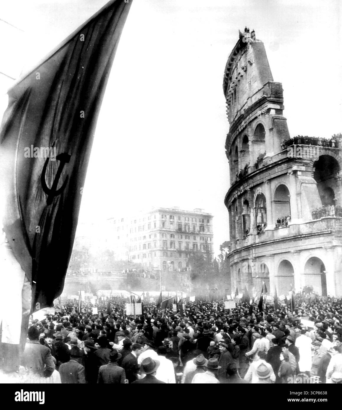 Italiener demonstrieren gegen Roatta - die Römer massierten über das alte Kolosseum in Einer Demonstration gegen LT. General Mario Roatta, dessen Prozess als Kriegsverbrecher unterbrochen wurde, als er aus einem Militärkrankenhaus entkommen war. Später marschierte die Menge zum Quirinale, dem königlichen Palast Roms, wo bei einem Zusammenstoß mit den berittenen Carabinieri ein Mann getötet und mehrere verletzt wurden. Links ist ein kommunistisches Banner mit Hammer und Sichel. 13. März 1945. (Foto von AP Wirephoto). Stockfoto