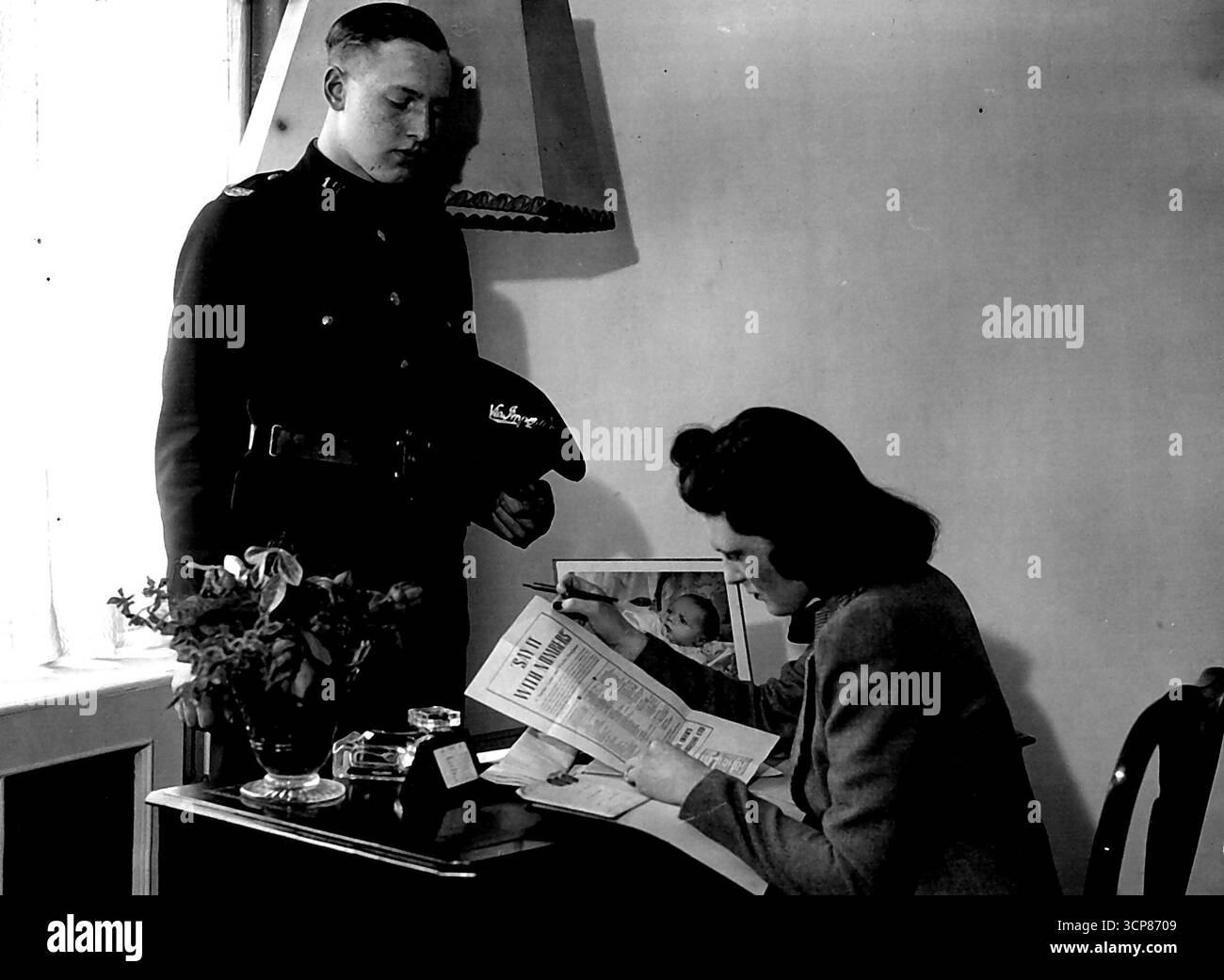 "Sagen Sie es mit Zahlen" für die Dienste -- 46-44-37, diese Zahlen bilden die Nachricht, die Mrs. Randolph Churchill, die Schwiegertochter des Premierministers, an ihren Mann im Nahen Osten im Rahmen des neuen "Sag es mit Zahlen" Scheme Ltd. Heute (Montag), in Zusammenarbeit mit dem G.P.O. die Botschaft, die Mr. Randolph Churchill erhalten hat, lautet: "Alles gut zu Hause, liebste Liebe und Küsse, Grüße von uns allen". Auf dem Tisch ist ein Porträt von Mr. Und Mrs. Randolph Churchills Sohn. September 1941. Stockfoto