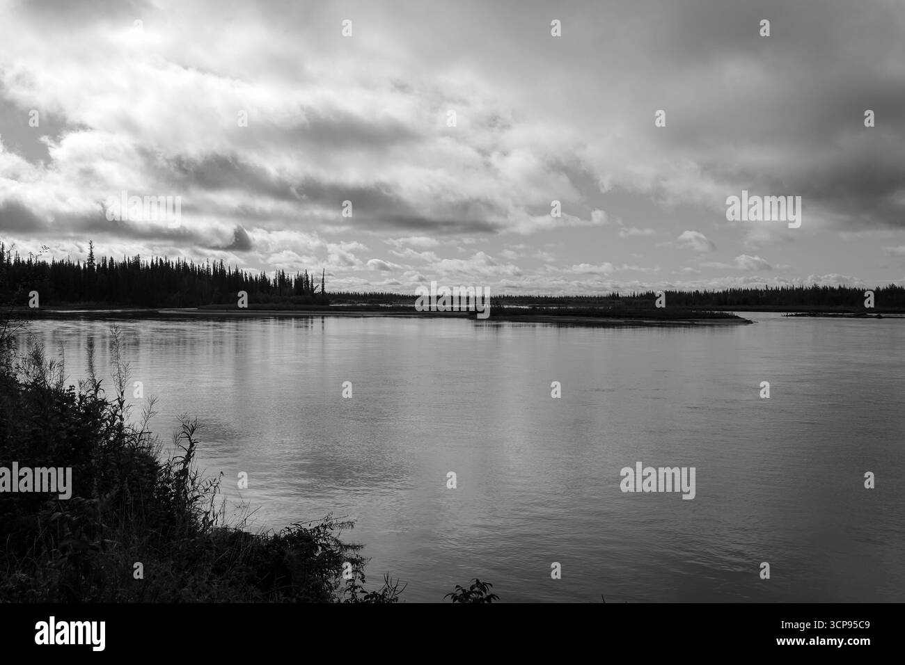 Dunkle Wolken spiegeln sich in einem See. Stockfoto