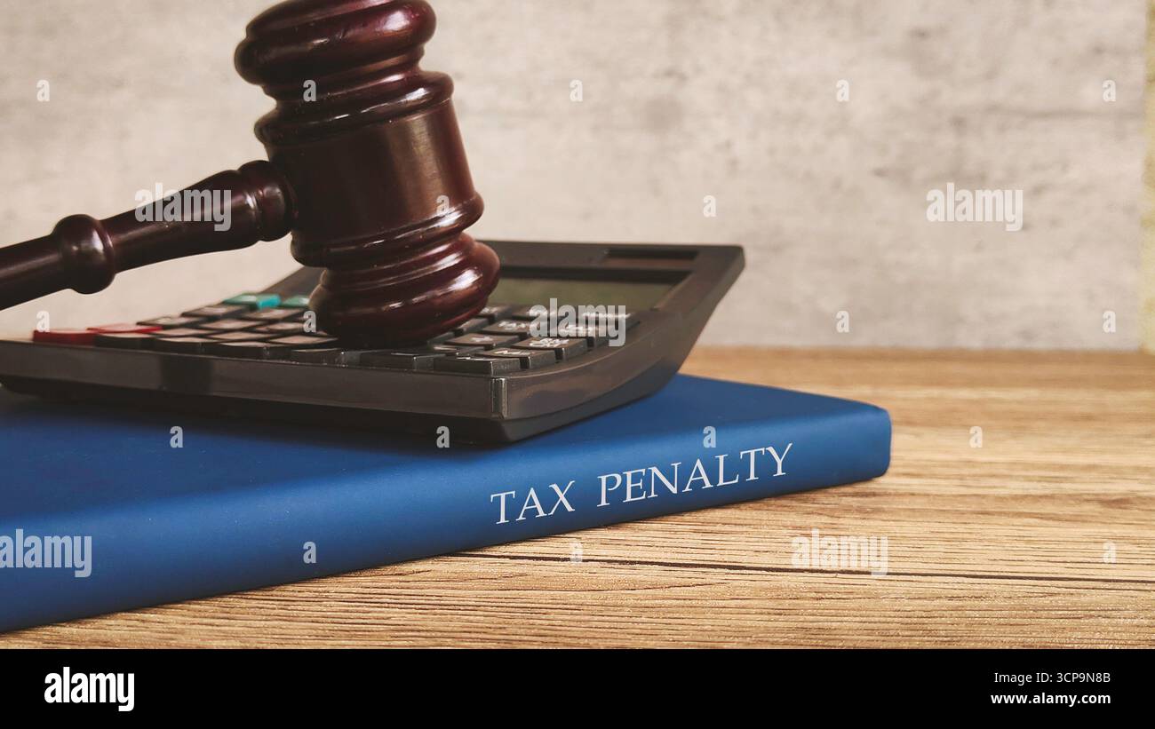 Ein Hammer und Taschenrechner auf einem Buch mit dem Titel "STEUERSTRAFE", das finanzielle und rechtliche Konsequenzen darstellt. Stockfoto