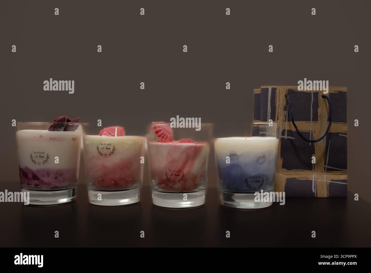 Produktfoto von handgegossenen Kerzen in Glasbehältern, minimalistisches Design für Wohnkultur und Entspannung, aufgenommen auf einem Hintergrund. Stockfoto